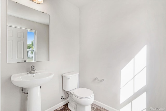 4442 Sprauge Ln, Swartz Creek, MI 48473 - bathroom with toilet, baseboards, and wood finished floors