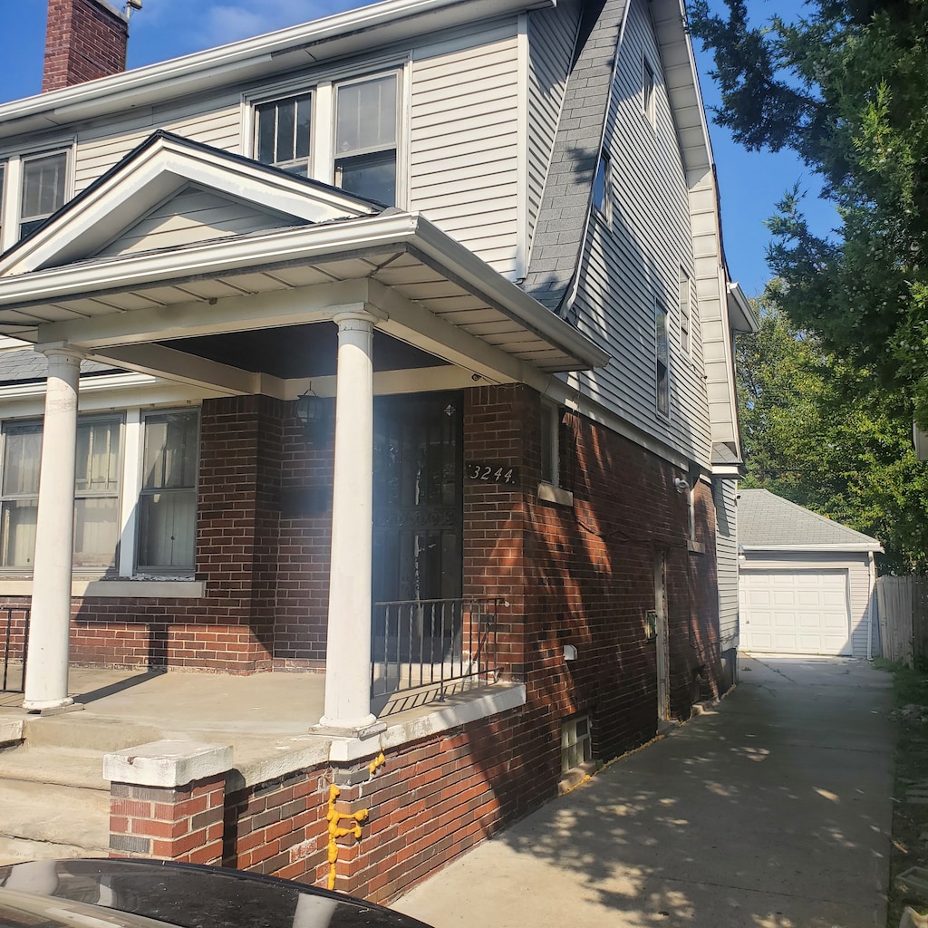 view of front of house with a porch, a garage, and an outdoor structure