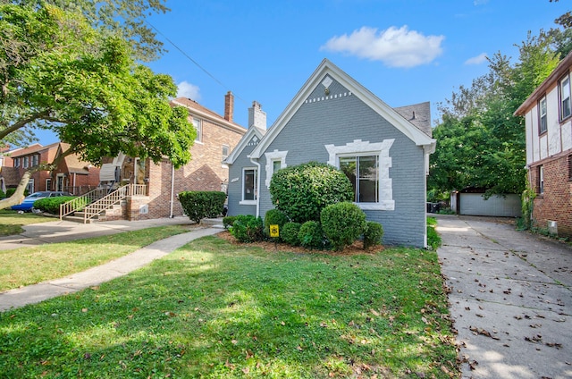 view of front of home featuring a garage, an outbuilding, and a front yard