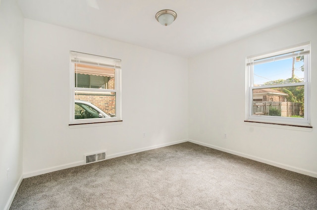 carpeted spare room featuring plenty of natural light