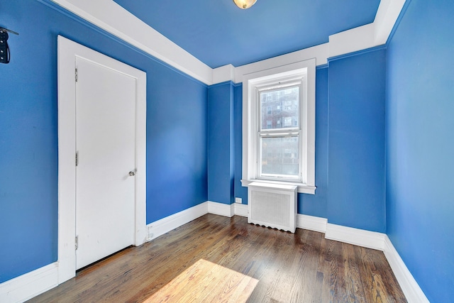 unfurnished room with radiator heating unit and dark wood-type flooring