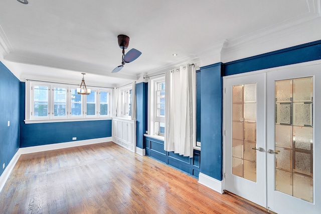 spare room featuring wood-type flooring, french doors, and crown molding