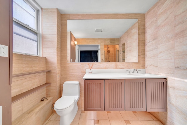 bathroom featuring tile patterned floors, walk in shower, vanity, tile walls, and toilet