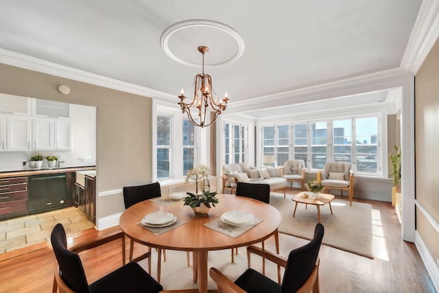 dining area with a notable chandelier, light hardwood / wood-style floors, and crown molding