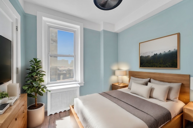 bedroom featuring radiator and hardwood / wood-style floors