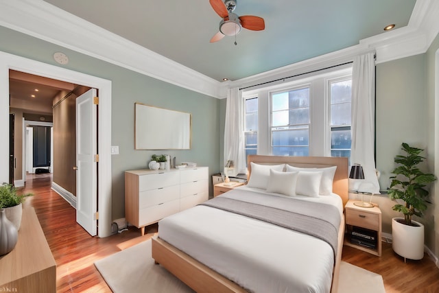 bedroom featuring ceiling fan, crown molding, and light hardwood / wood-style floors