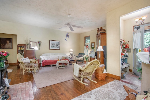 living room with hardwood / wood-style floors and ceiling fan with notable chandelier