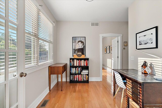 office with light wood finished floors, visible vents, and baseboards