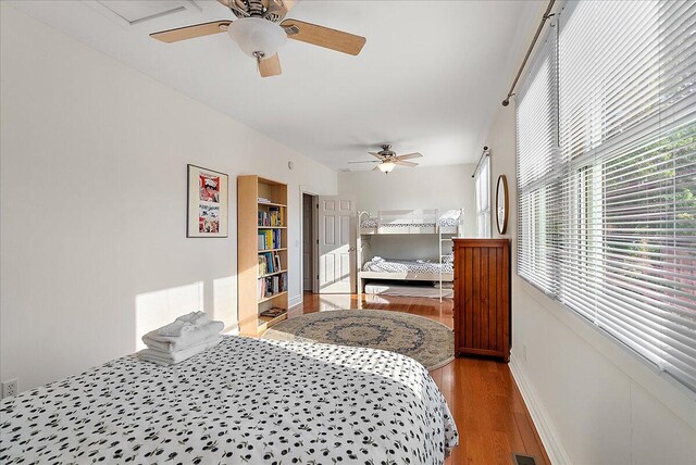 bedroom with wood finished floors, a ceiling fan, and baseboards