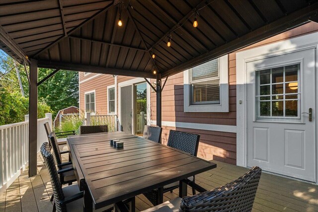 wooden deck featuring a gazebo and outdoor dining space