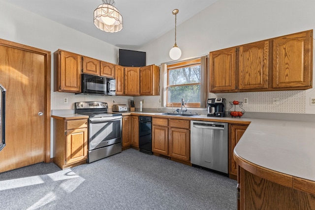 kitchen featuring decorative backsplash, sink, pendant lighting, and appliances with stainless steel finishes