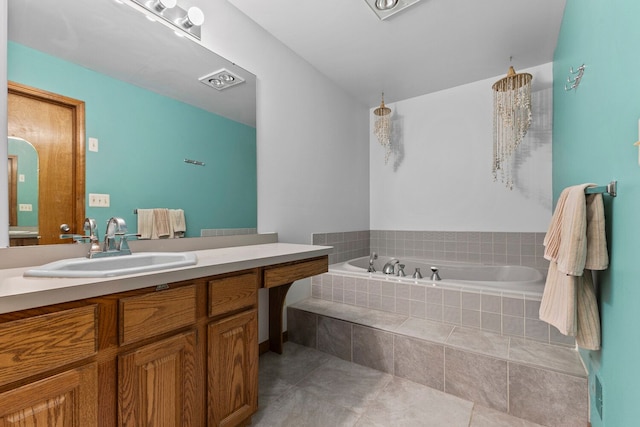 bathroom featuring tile patterned floors, tiled bath, and vanity