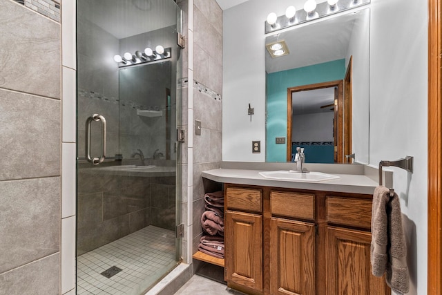 bathroom featuring tile patterned floors, vanity, and a shower with shower door