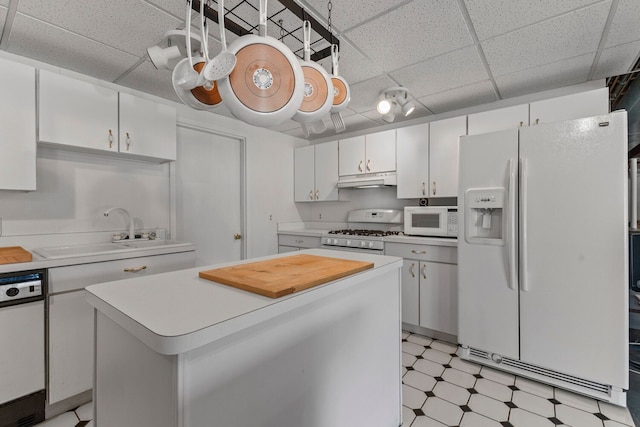 kitchen featuring a center island, sink, white appliances, a paneled ceiling, and white cabinets