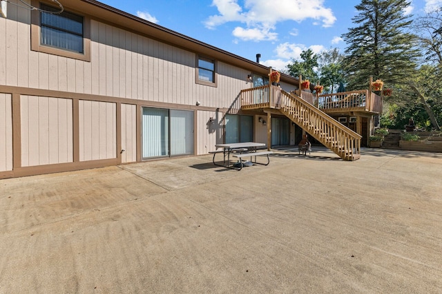 rear view of property featuring a patio and a deck