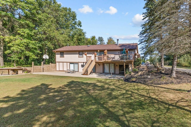 rear view of property with a lawn, a patio, and a deck