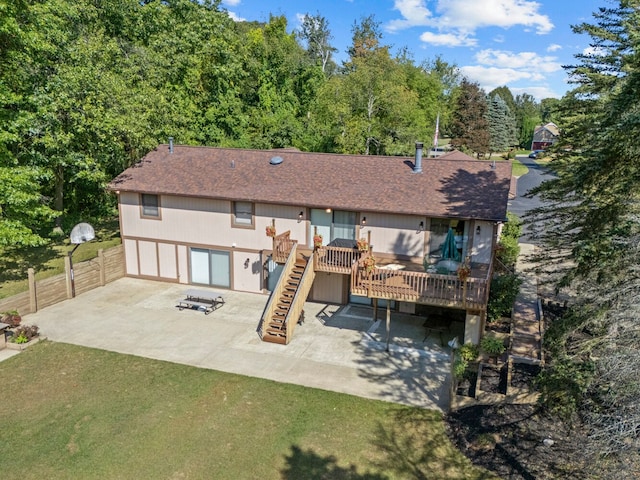 back of property with a yard, a patio, and a wooden deck