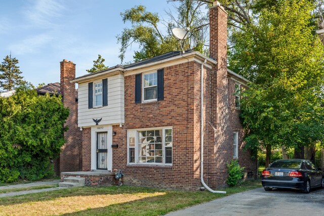 16652 Hubbell St, Detroit, MI 48235 - view of front of home with a chimney, brick siding, and a front lawn