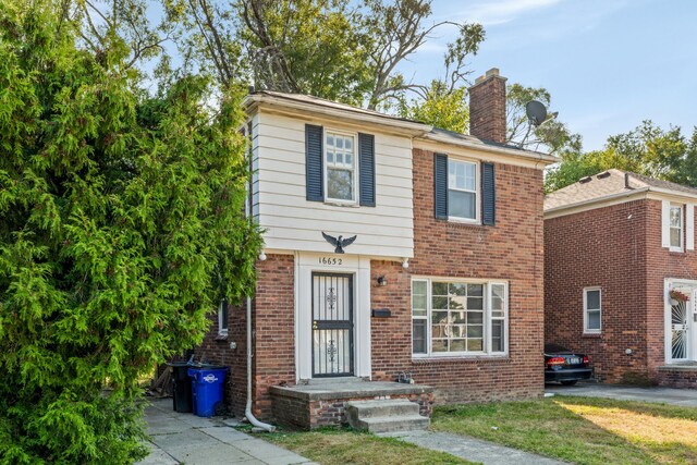 16652 Hubbell St, Detroit, MI 48235 - view of front of house with a chimney, brick siding, and a front yard