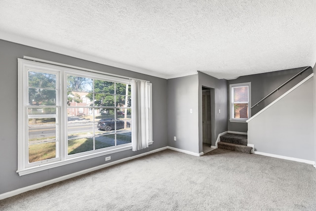 unfurnished living room featuring a textured ceiling and carpet floors