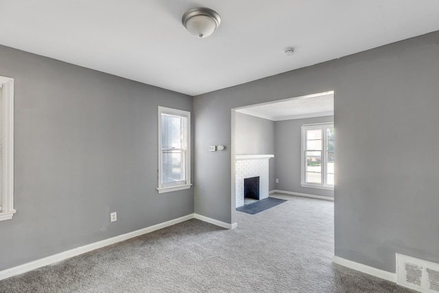 unfurnished living room featuring a fireplace and carpet flooring