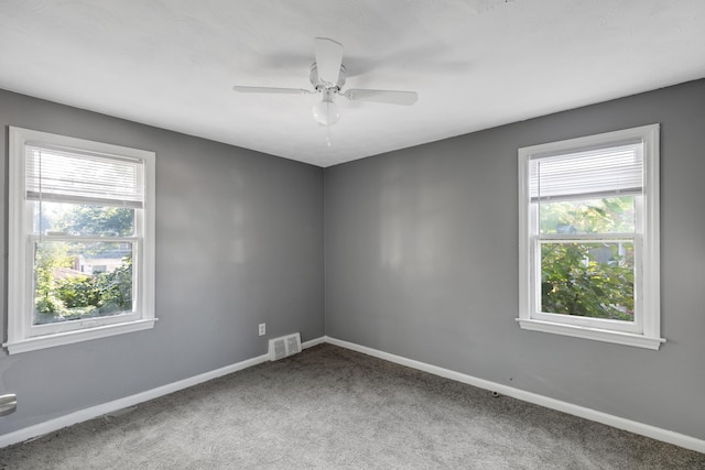 carpeted spare room with a wealth of natural light and ceiling fan