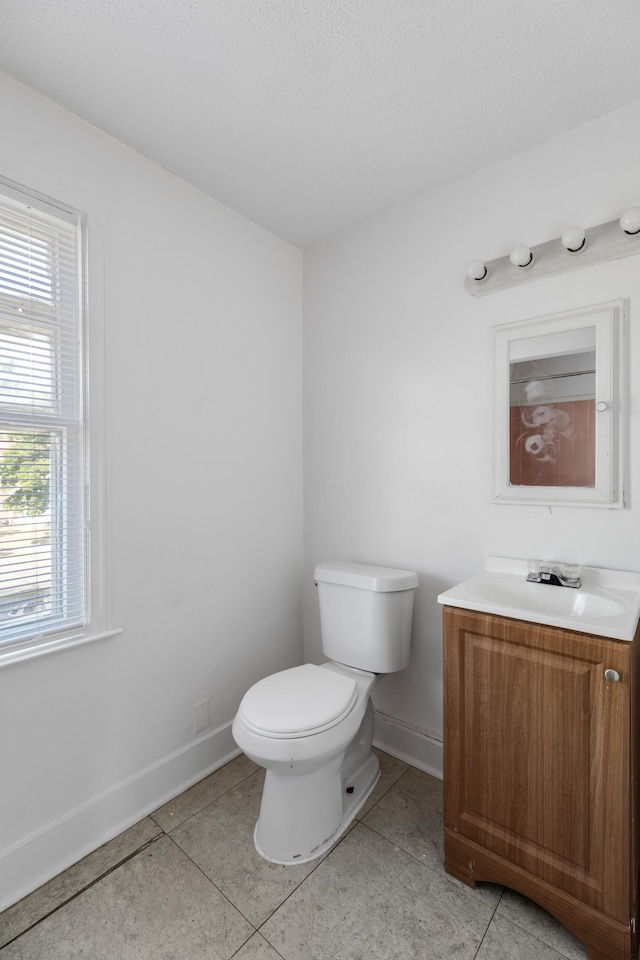 bathroom featuring tile patterned floors, vanity, a textured ceiling, and toilet