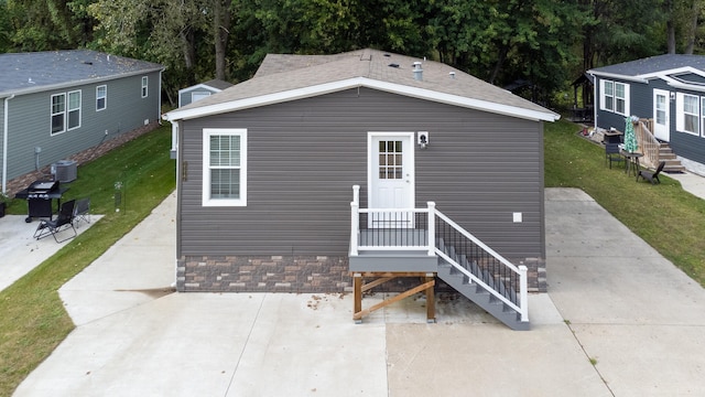 view of front of home featuring central AC unit, a patio, and a front yard