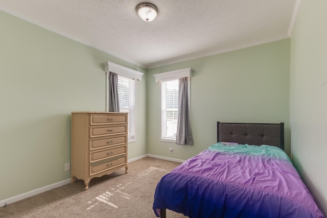 carpeted bedroom featuring a textured ceiling and crown molding