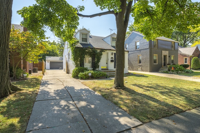 view of front of property featuring central air condition unit, an outbuilding, a front lawn, and a garage