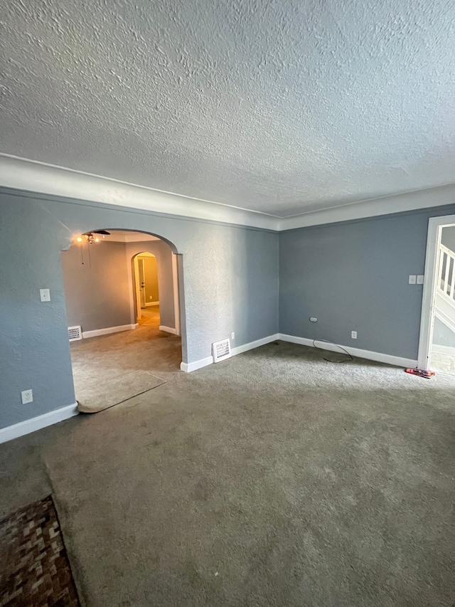 unfurnished room with carpet and a textured ceiling