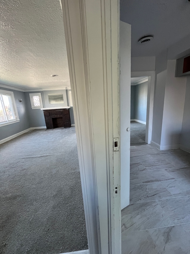 hallway featuring a textured ceiling and light colored carpet