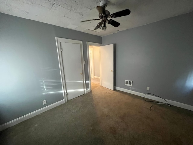 unfurnished bedroom with carpet, baseboards, ceiling fan, and visible vents