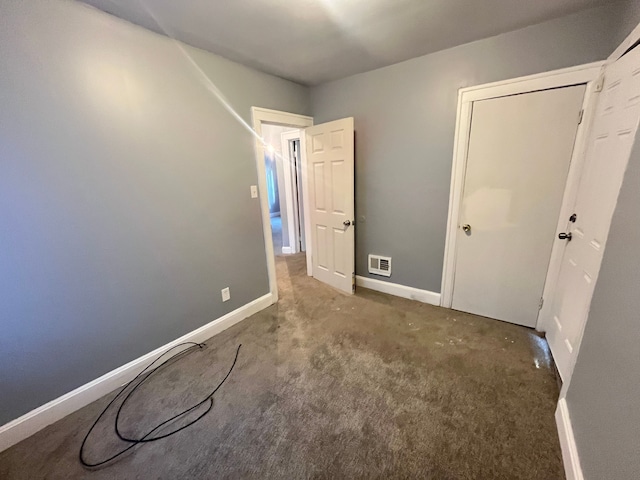 unfurnished bedroom with carpet floors, baseboards, and visible vents