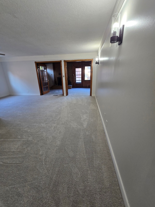 carpeted empty room with a textured ceiling