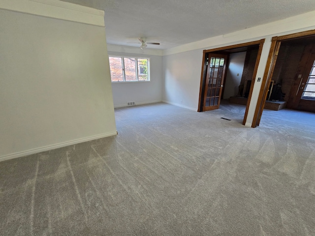 carpeted spare room featuring a textured ceiling and ceiling fan