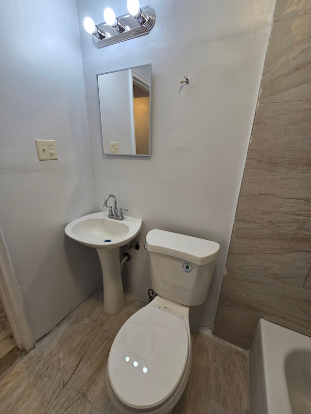 bathroom with toilet and a tub