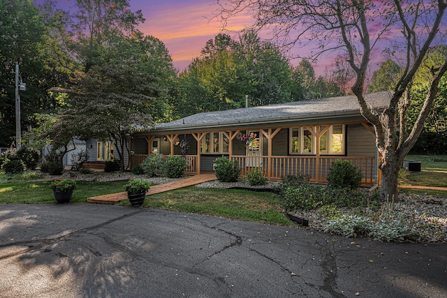 ranch-style home with covered porch and central AC unit