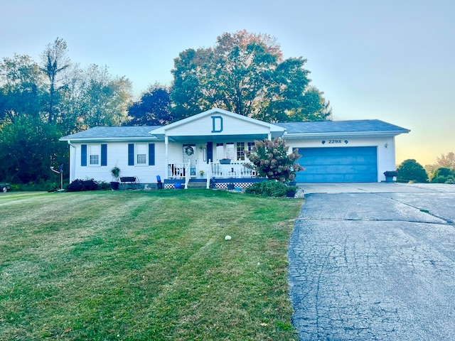 ranch-style house with a yard, a porch, and a garage