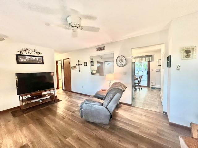 living room with wood-type flooring, a baseboard radiator, and ceiling fan