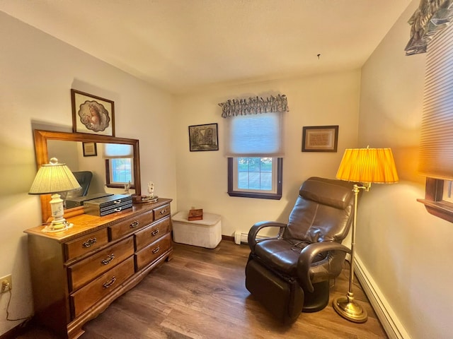 living area featuring dark hardwood / wood-style floors and a baseboard heating unit