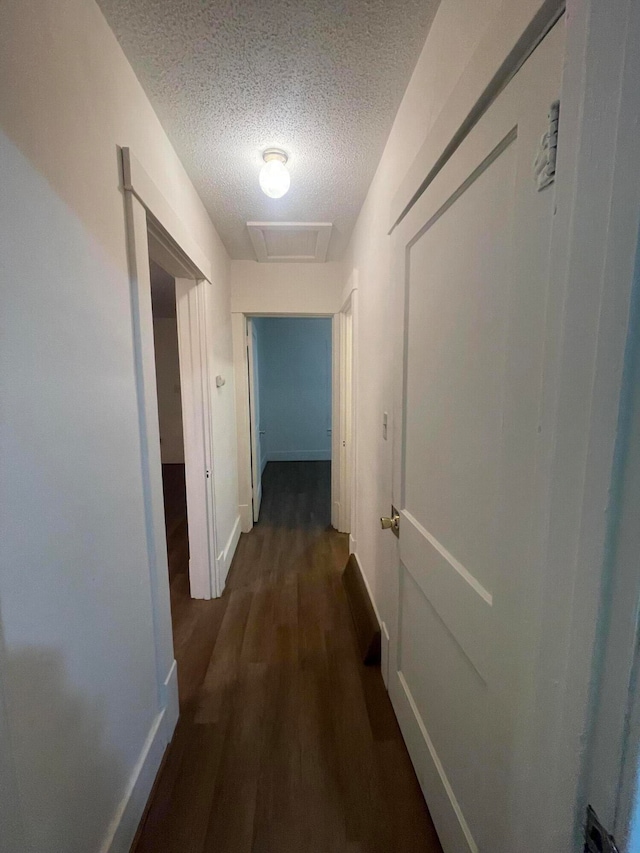 hall featuring dark hardwood / wood-style flooring and a textured ceiling