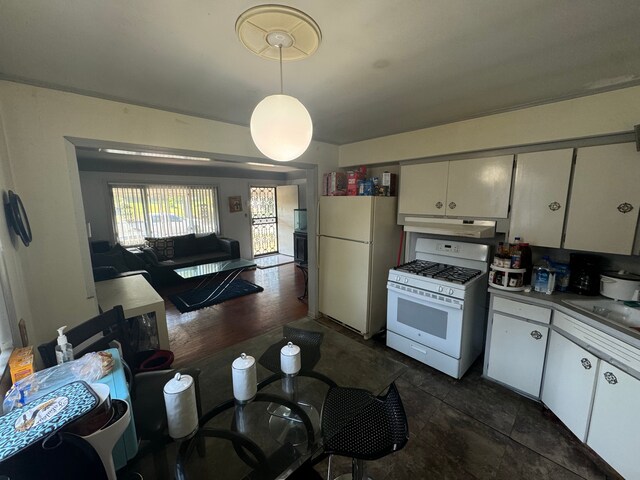 1408 W Pasadena Ave, Flint, MI 48504 - kitchen with white appliances, under cabinet range hood, hanging light fixtures, white cabinets, and open floor plan