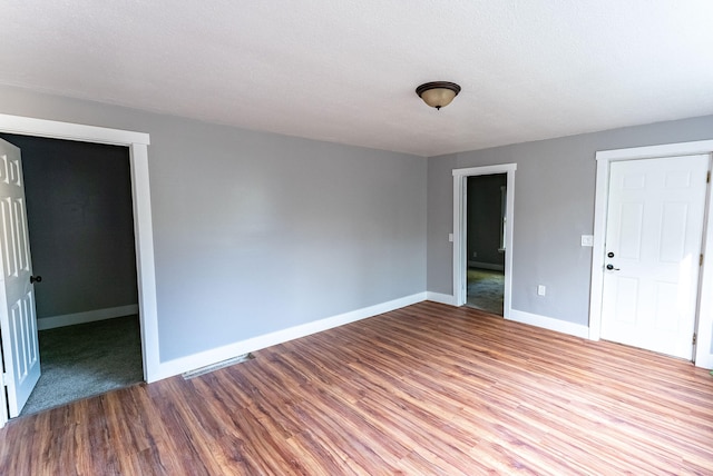 spare room featuring wood-type flooring and a textured ceiling