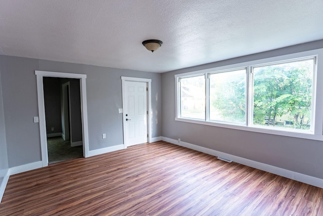 interior space with a textured ceiling and hardwood / wood-style flooring