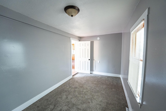 carpeted empty room featuring a textured ceiling