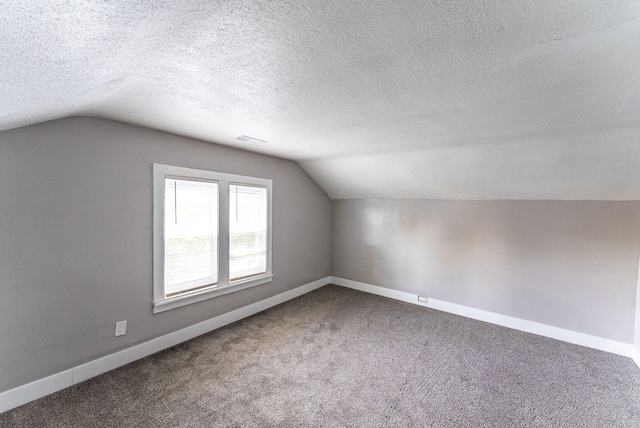 bonus room with a textured ceiling, carpet floors, and lofted ceiling