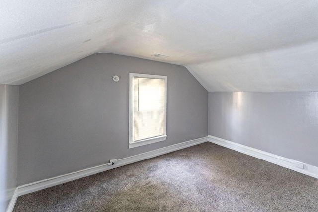 bonus room with vaulted ceiling, carpet flooring, and a textured ceiling