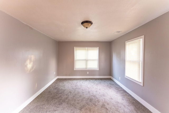 carpeted empty room featuring a textured ceiling