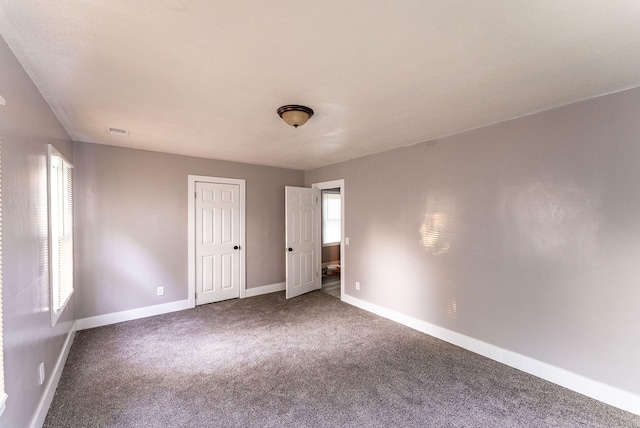 unfurnished bedroom with multiple windows and carpet